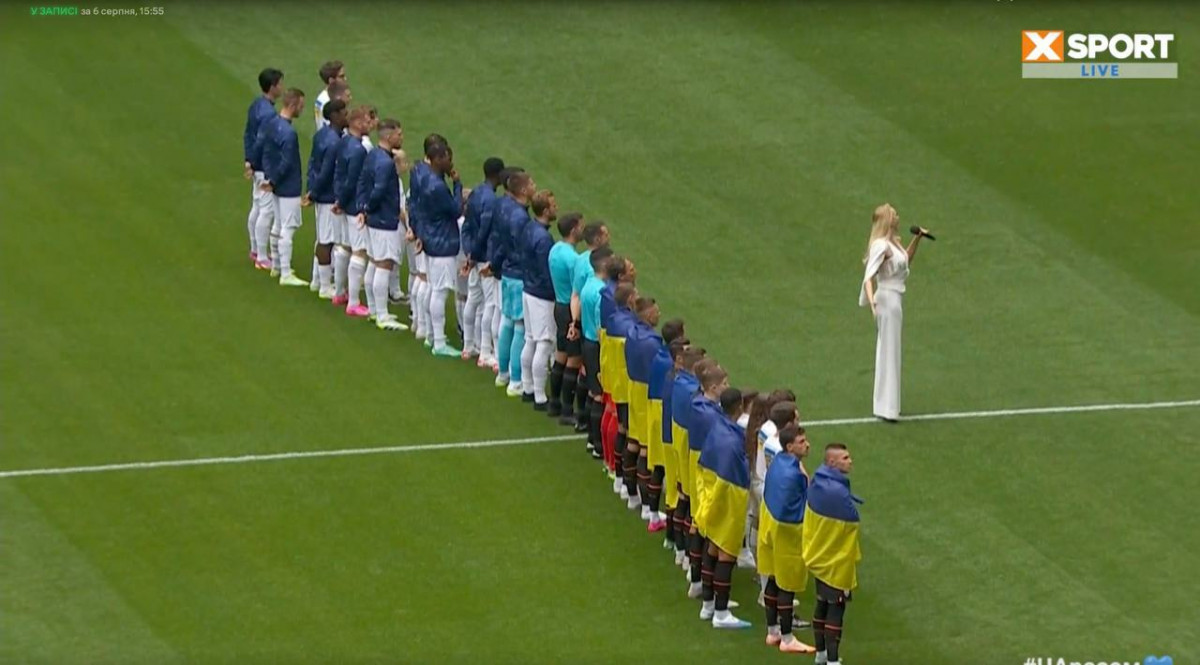 Оля Полякова исполняет гимн Украины.